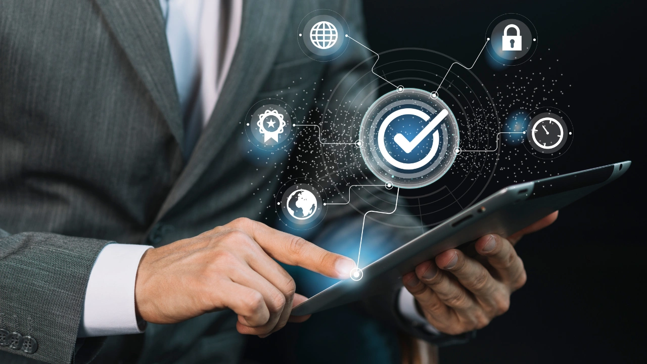 Building Cyber Resilience For Business Continuity Image of a person holding a tablet with icons for security, compliance, time and the world reflected from the screen